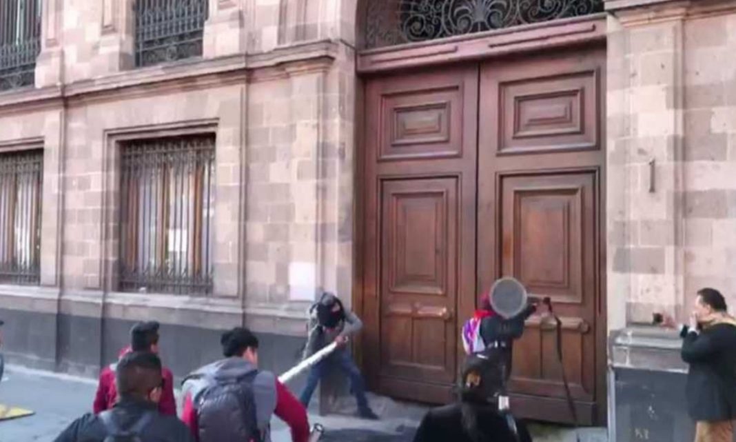 Normalistas dañan puerta de Palacio Nacional durante manifestación