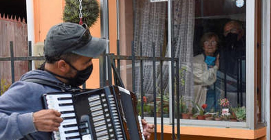 Toca el acordeón en la ventana para animar a sus padres en cuarentena