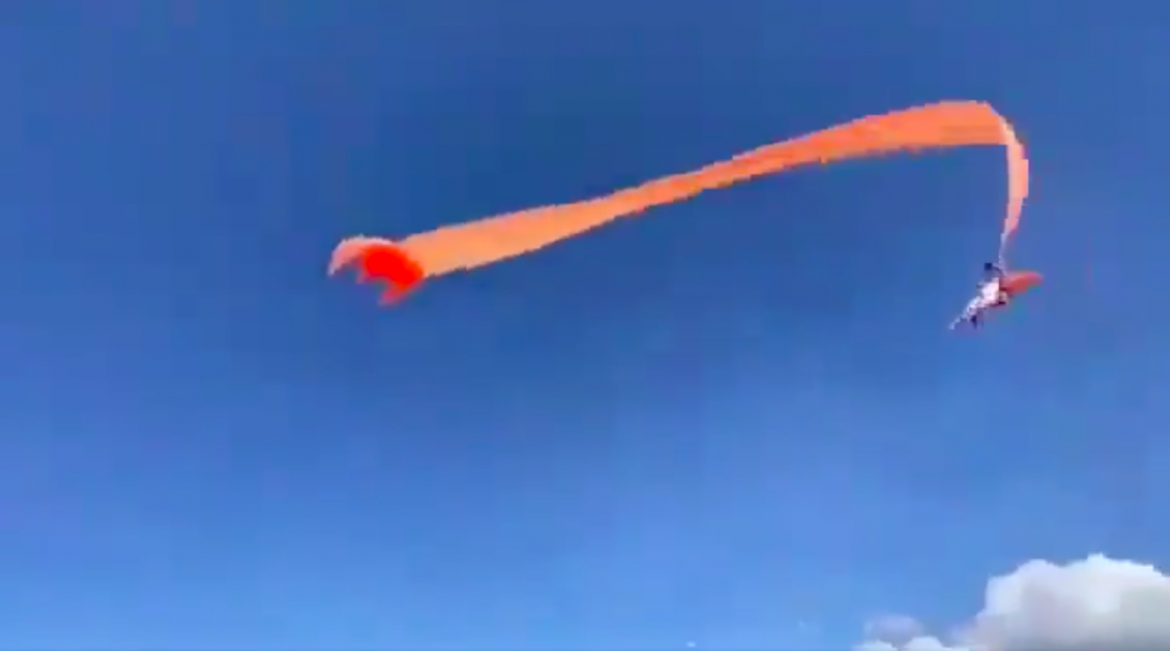 Niña vuela por el cielo aferrada a una cometa
