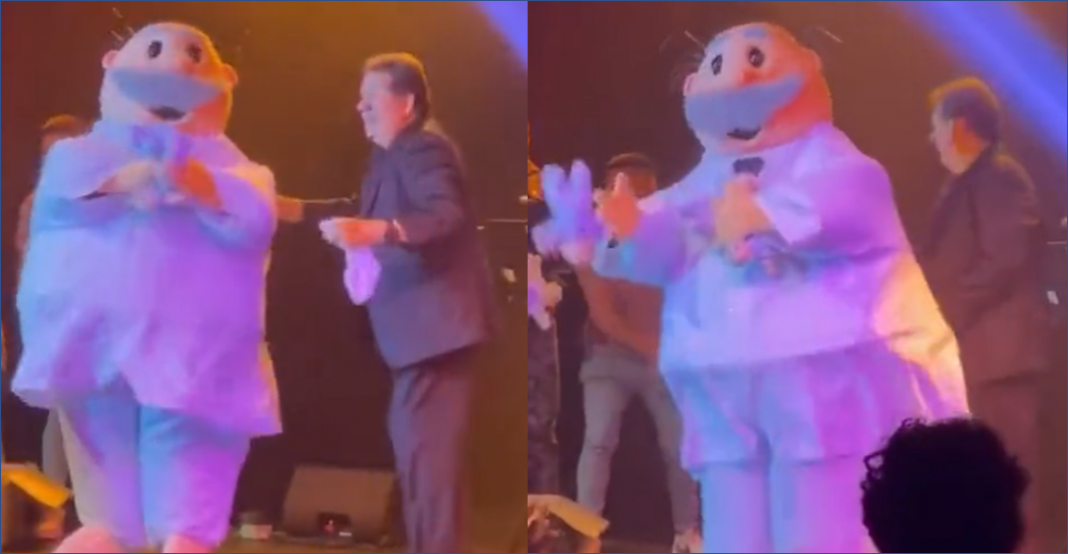 El Dr. Simi lanza peluches de sí mismo al público
